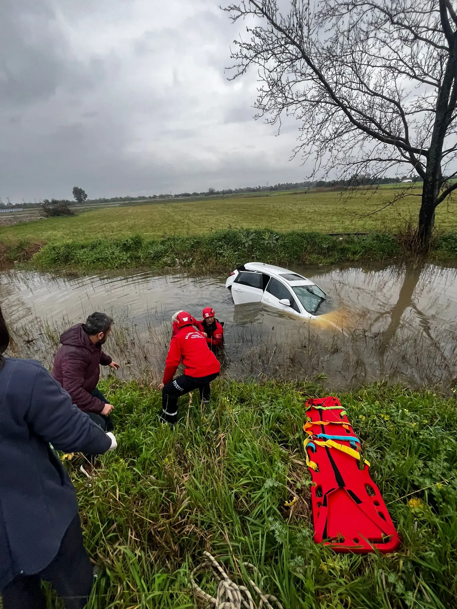 Burhaniye’de su kanalına düşen araçın sürücüsünü itfaiye çıkardı